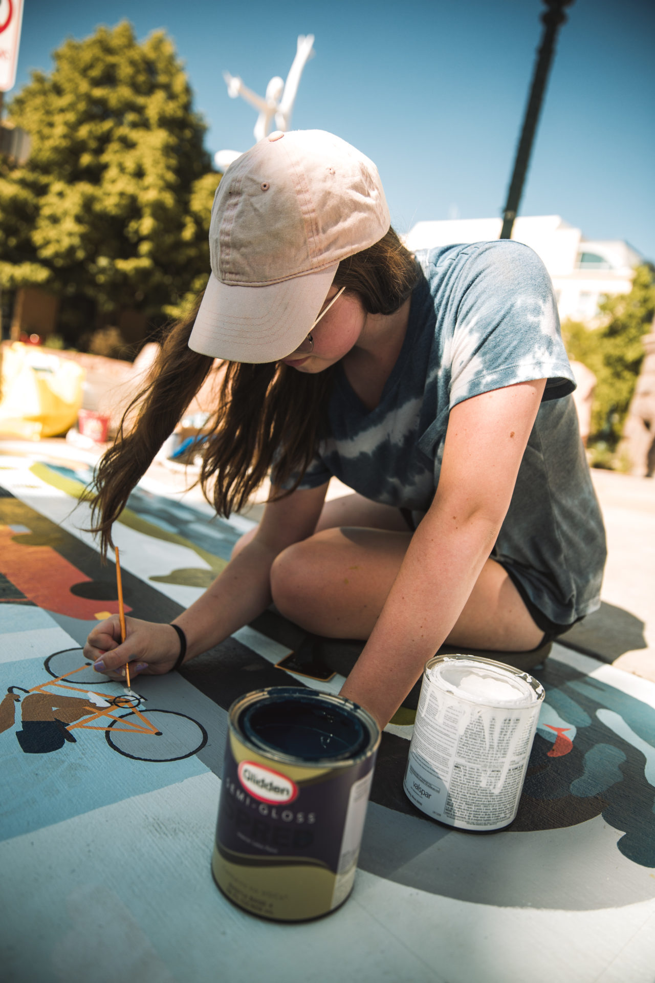 Carly painting a bicycle on the ground